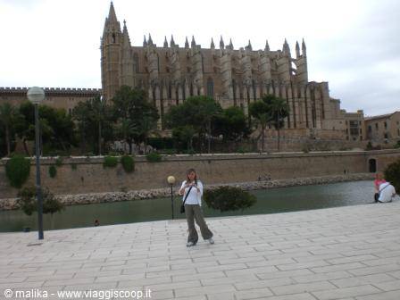Tourist poses on the paved promenade in front of Palma cathedral
