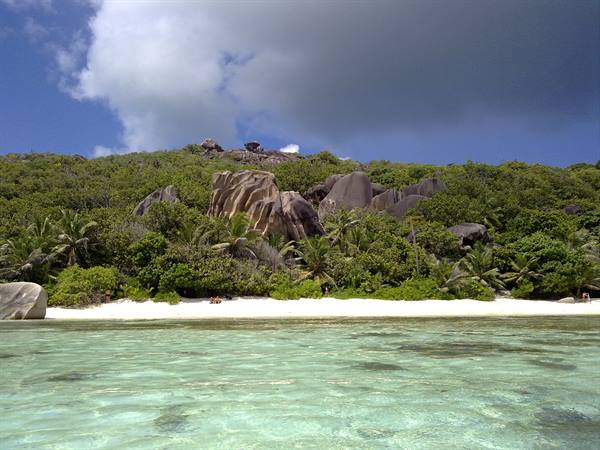 Clear turquoise water, white beach and large granite boulders at La Digue
