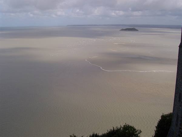 Tidal sands and sea in Mont-Saint-Michel bay, with Tombelaine in the distance