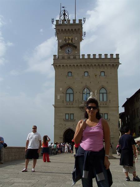 Tourist in pink top in front of San Marino's Public Palace clock tower