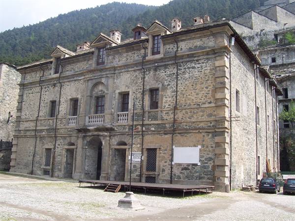 Three-story stone building at Fenestrelle Fort, beneath forested mountains