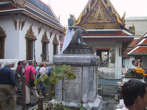 Tourists near the Rama III statue at Wat Pho, among lotus plants