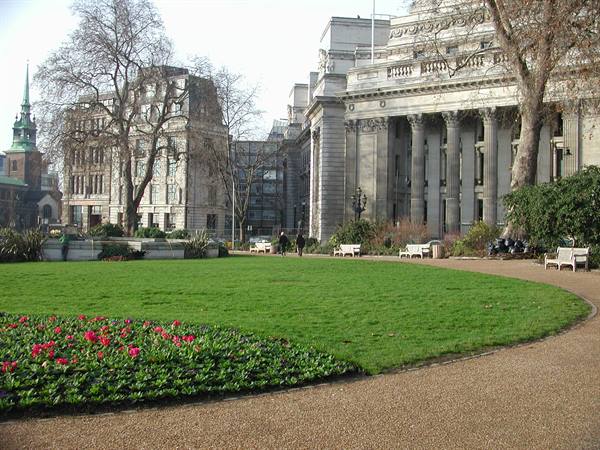 Garden with red tulip beds and neoclassical colonnaded building in Whitehall