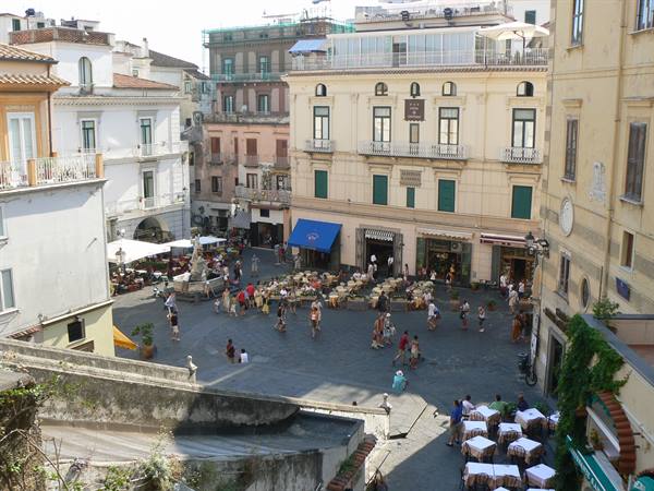 Piazza Tasso in Sorrento, tourists and café tables among ochre buildings