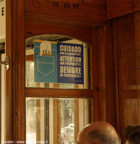 Beware of pickpockets sign inside a vintage wooden tram
