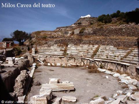 Marble cavea of the ancient theater of Milos, stone tiers and ruins under blue sky