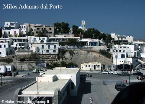 The port of Adamas in Milos, white houses and bell tower under the sun