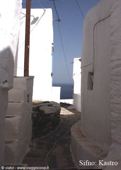 Flagstone alley between whitewashed walls in Sifnos, Kastro, sea at the end
