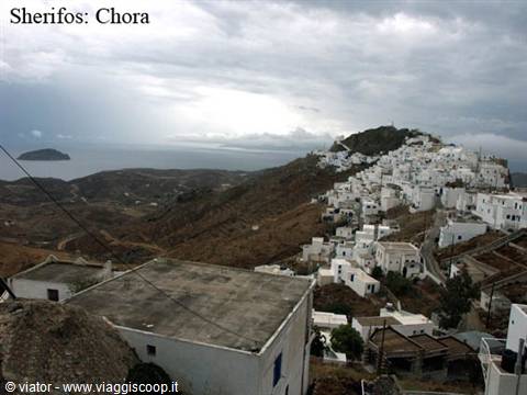 Whitewashed houses of Chora on dry hill under cloudy sky in Serifos
