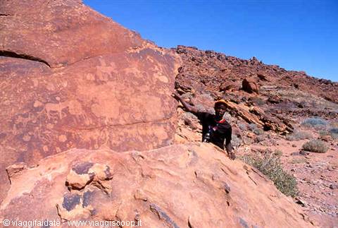 Guide beside the Twyfelfontein rock engravings on red sandstone