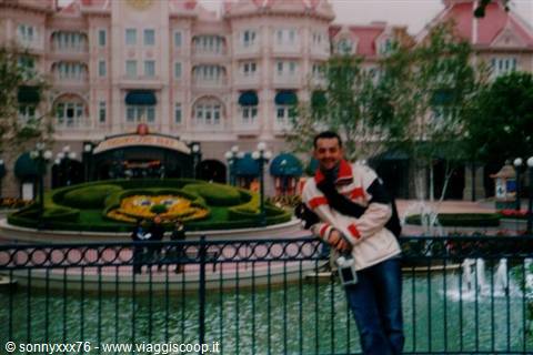 Man leaning on the fence in front of the Disneyland Hotel