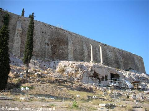 Massive Acropolis walls with columns, cypresses and scaffolding under blue sky