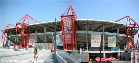 Stadium with massive red steel girders under a blue sky