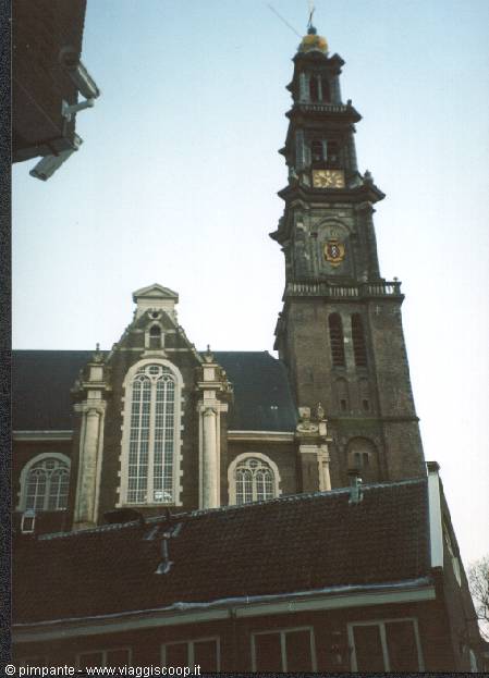 Brick baroque bell tower of the Westerkerk in Amsterdam among dark rooftops