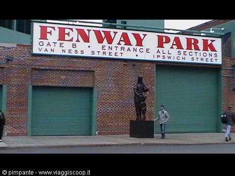 Fenway Park sign on red brick, bronze statue and pedestrians in Boston