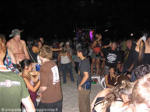 Night beach party, young crowd dancing on the sand
