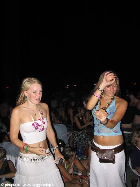 Two girls dance at night on Koh Phangan beach during the Full Moon Party
