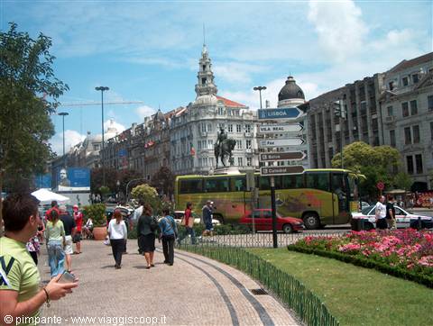 Tourists walk toward Porto city hall with equestrian statue and yellow bus