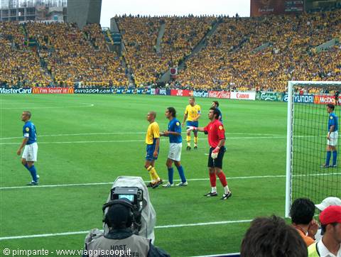Brazil in yellow jerseys playing at Yokohama stadium, packed yellow stands