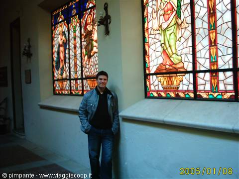 Man leaning on wall beside stained glass windows with religious figures
