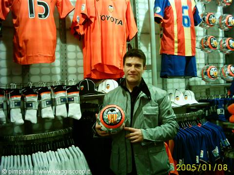 Valencia shop: man holding a football among orange jerseys and scarves