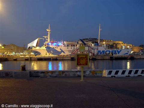 Moby ferry lit up at the dock in Olbia harbor at night
