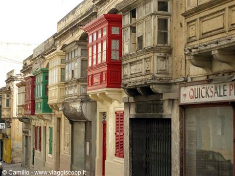 Colorful wooden Maltese balconies on limestone facades, Quick Sale sign