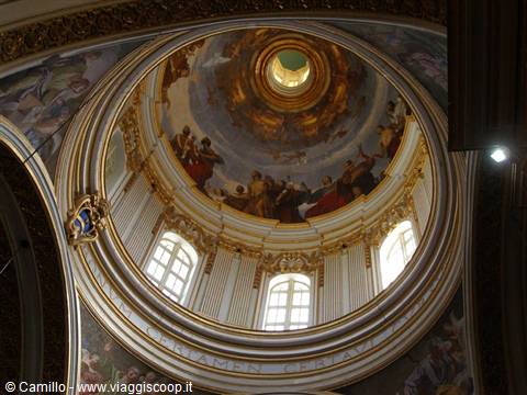 Frescoed dome with white windows and golden light inside the church