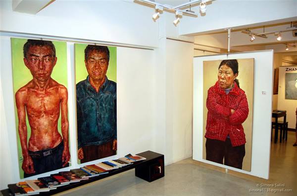 Painted farmer portraits exhibited in a white art gallery