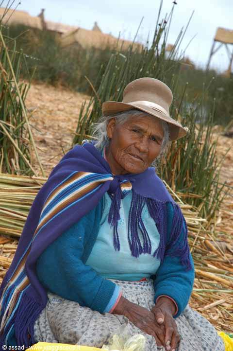 Elderly woman in bowler hat and purple shawl among totora reeds, Uros