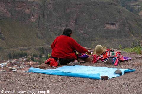 Woman in red sells textiles with straw hat, Pisac sacred valley