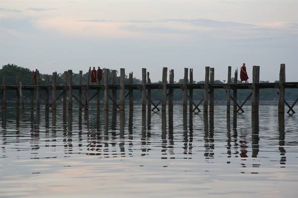 Monks in red robes cross the teak U Bein bridge, Amarapura