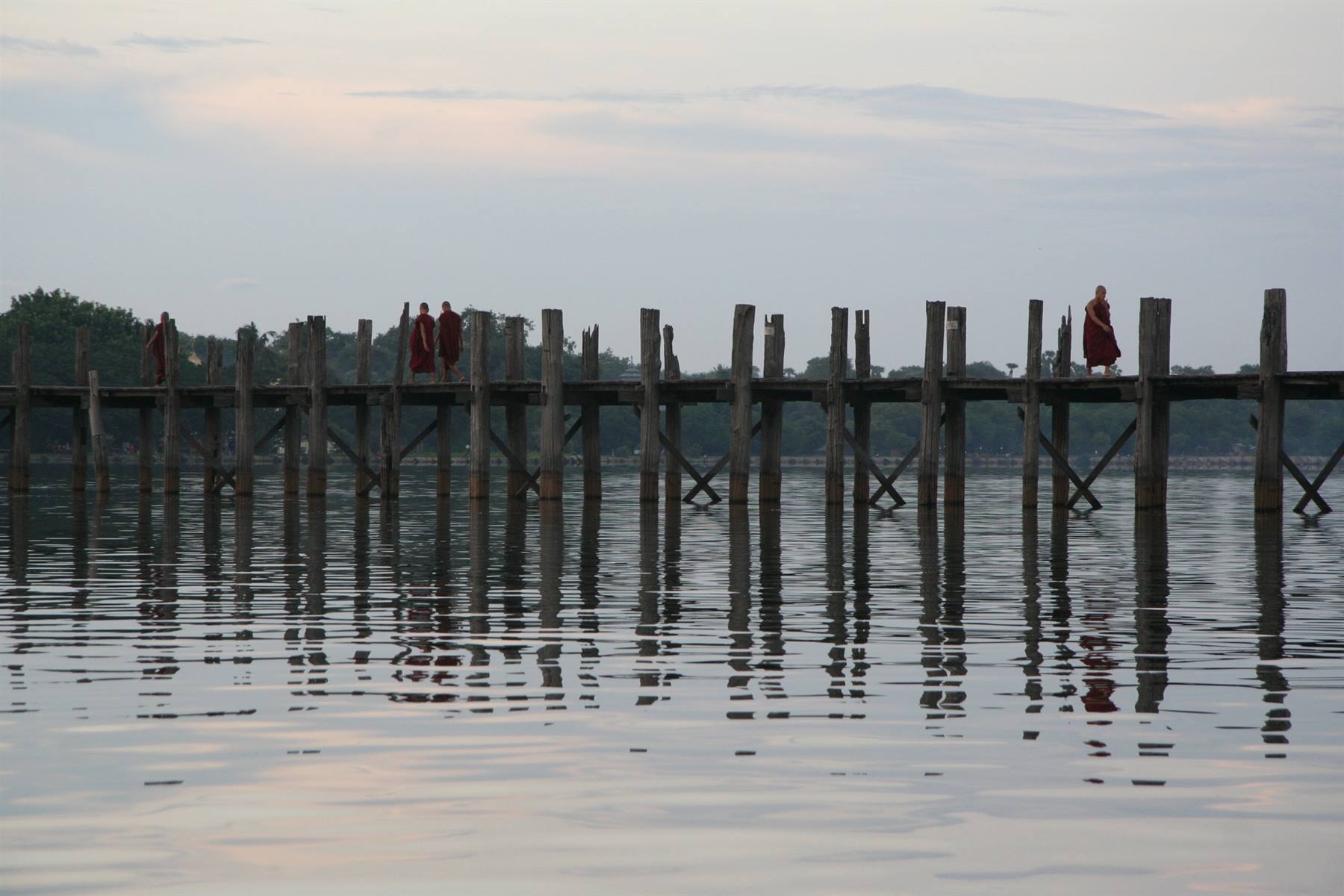 Monaci in tunica rossa attraversano il ponte di teak U Bein, Amarapura