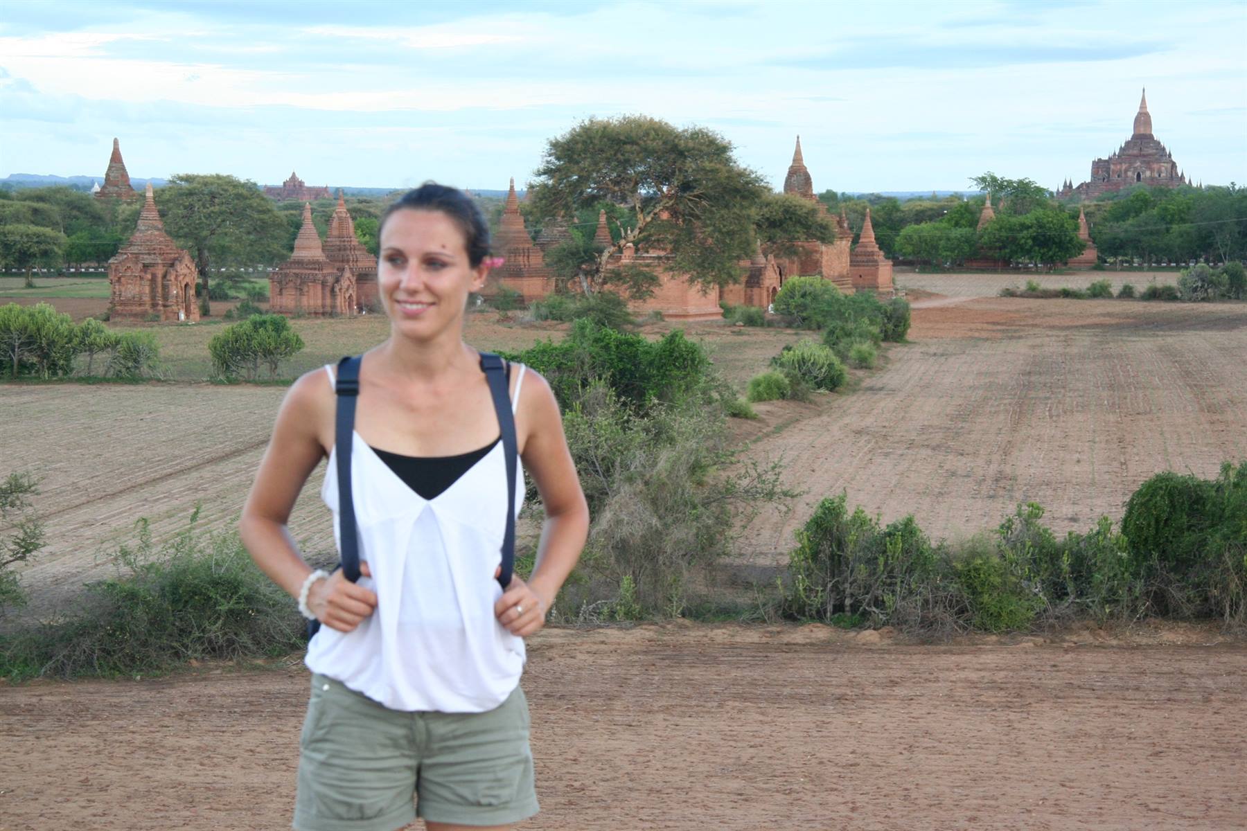 Viaggiatrice con zaino tra i templi in mattoni di Bagan