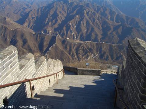 Stone staircase with crenellations along the Great Wall over barren mountains