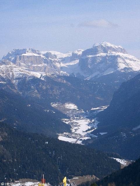 Snow-capped Sella massif above a valley with villages, Dolomites