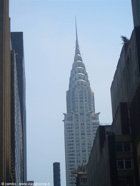 The Chrysler Building rising between Manhattan skyscrapers in the haze