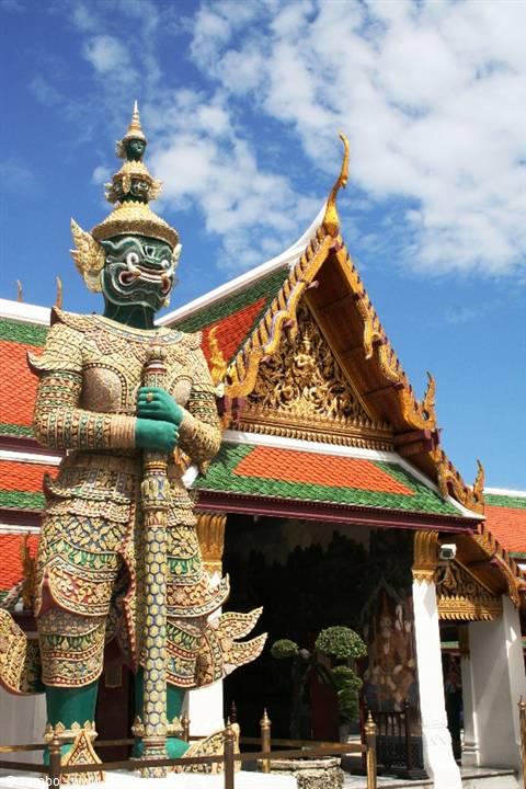Green and gold yak guardian statue in front of Wat Phra Kaew temple