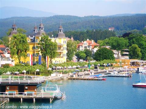 Velden am Wörthersee: yellow turreted building on the promenade, piers and boats