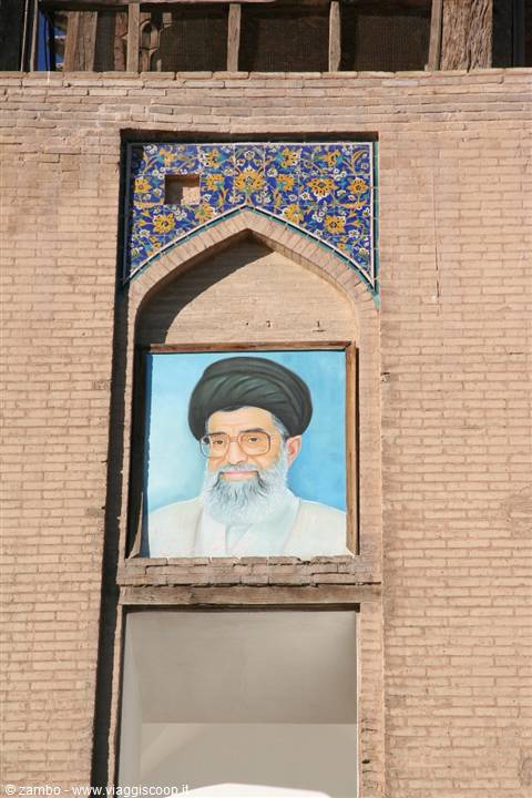 Portrait of a turbaned cleric on brick wall with blue tiles, Esfahan