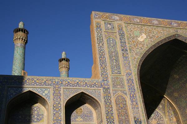 Shah Mosque in Esfahan, tiled minarets and iwan glowing in sunlight