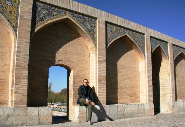 Tourist sitting under the brick arches of Si-o-se-pol bridge, Esfahan