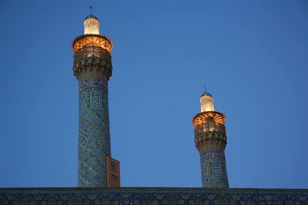 Illuminated minarets of Yazd Friday Mosque against the blue dusk
