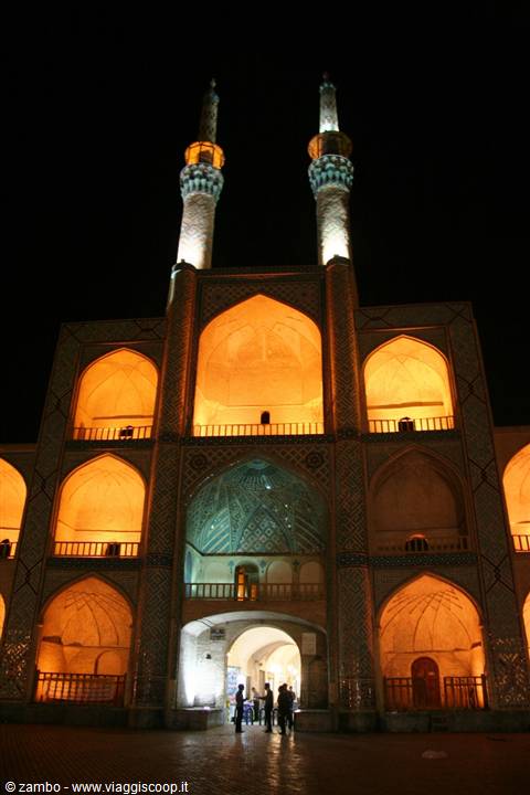 Amir Chakhmaq complex in Yazd lit at night, visitors below the iwans