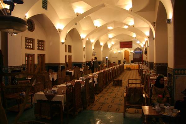 Restaurant hall with brick vaulted ceilings and set tables, likely Yazd