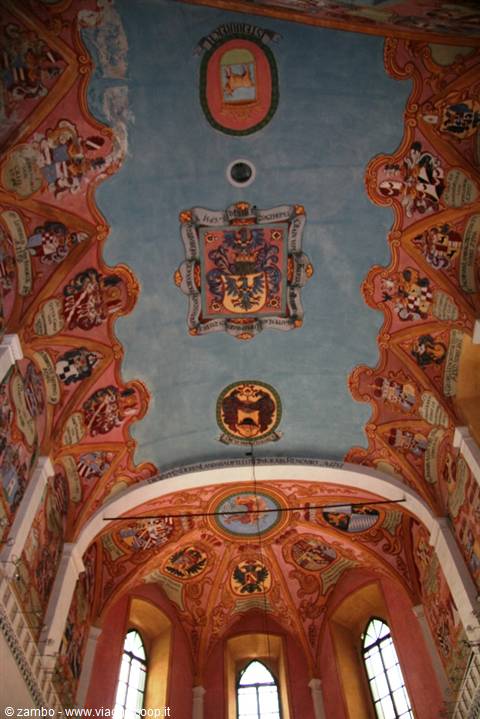 Church vaulted ceiling painted with coats of arms on blue and pink
