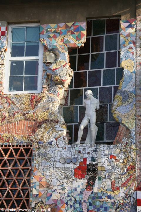 Male statue among colorful mosaics and windows at Metelkova, Ljubljana