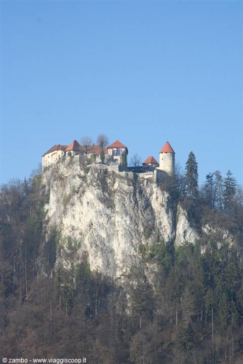 Bled Castle perched on the rocky cliff under blue sky