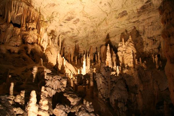 Illuminated stalactites and stalagmites inside a limestone karst cave