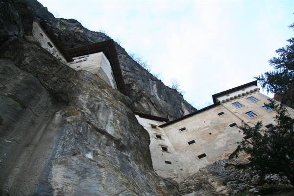 Predjama Castle built into the limestone cliff, white stone facade